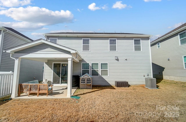 rear view of house with a lawn, a patio, and central AC