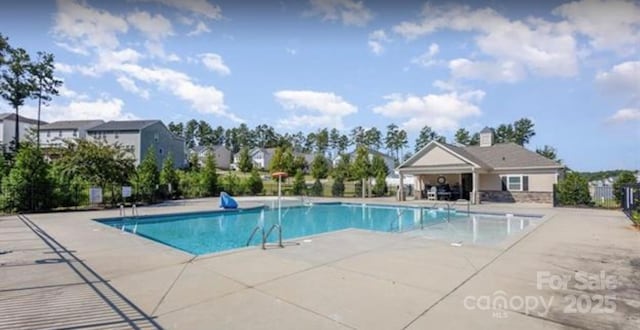 community pool featuring a patio and fence