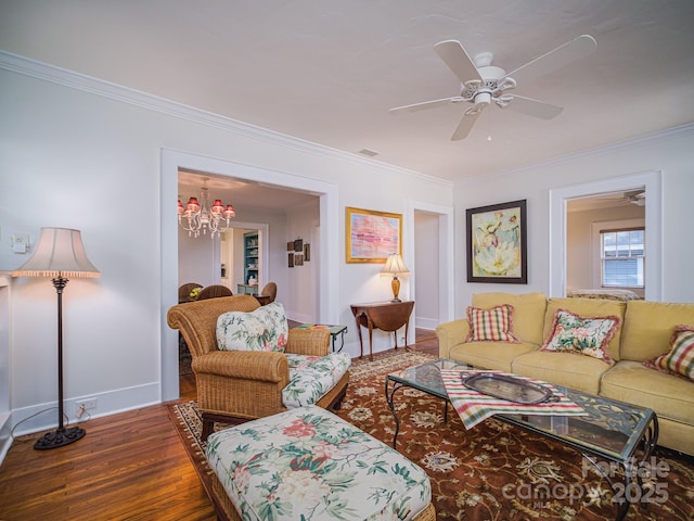 living room with hardwood / wood-style flooring, ornamental molding, and ceiling fan with notable chandelier