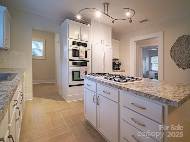 kitchen with crown molding, decorative backsplash, white cabinets, and white appliances