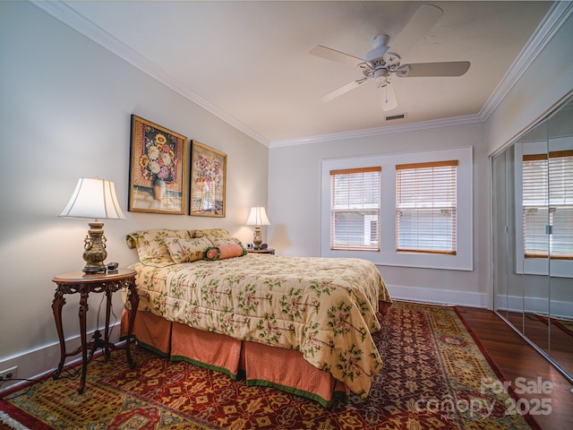 bedroom featuring ceiling fan, ornamental molding, a closet, and dark hardwood / wood-style floors