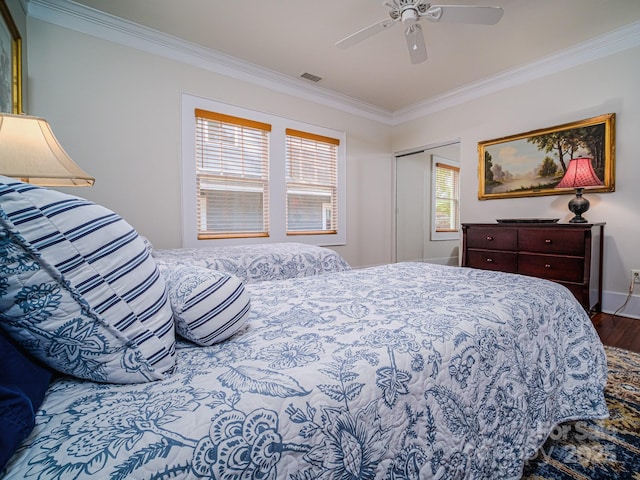 bedroom with ceiling fan, a closet, ornamental molding, and hardwood / wood-style flooring