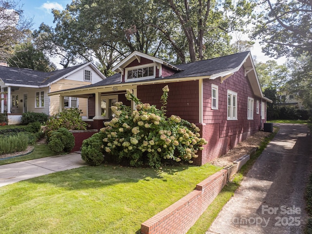 view of front of property with a front yard and central AC unit