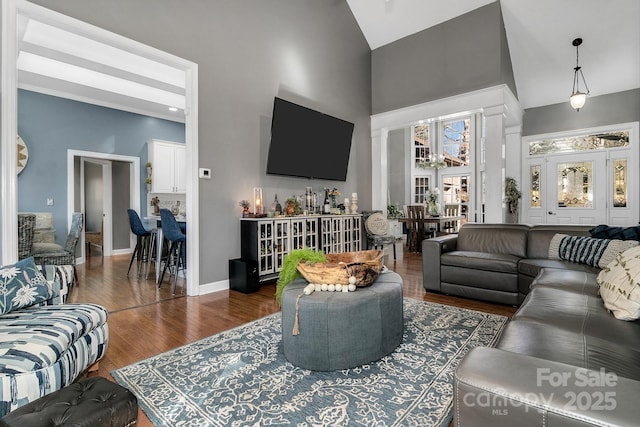 living room with dark hardwood / wood-style flooring, plenty of natural light, and high vaulted ceiling