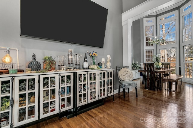 bar featuring wood-type flooring and a chandelier