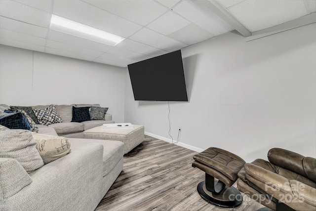 living room with wood-type flooring and a drop ceiling