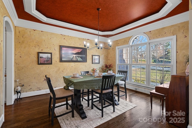 dining area with crown molding, a notable chandelier, a tray ceiling, and dark hardwood / wood-style floors