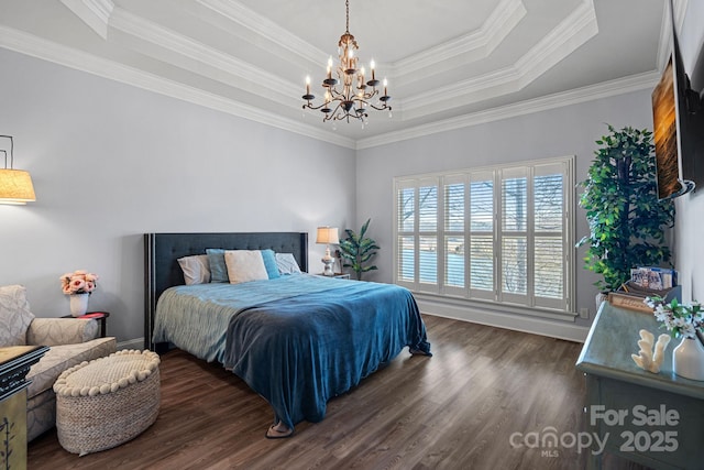 bedroom with dark hardwood / wood-style floors, ornamental molding, a tray ceiling, and a notable chandelier