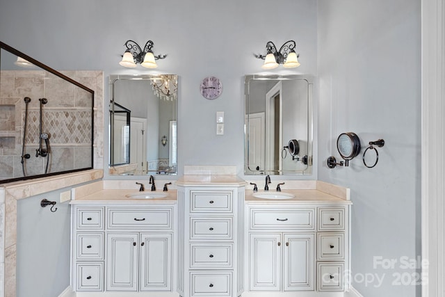 bathroom featuring tiled shower and vanity