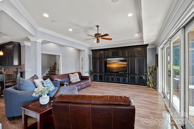 living room featuring ceiling fan, ornamental molding, light hardwood / wood-style floors, and ornate columns