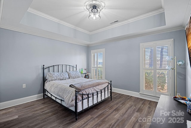 bedroom featuring a raised ceiling, ornamental molding, and dark wood-type flooring