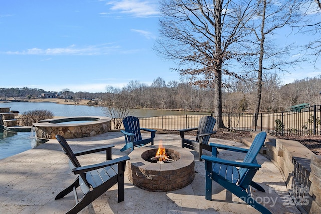 view of patio / terrace with a water view, pool water feature, an in ground hot tub, and a fire pit