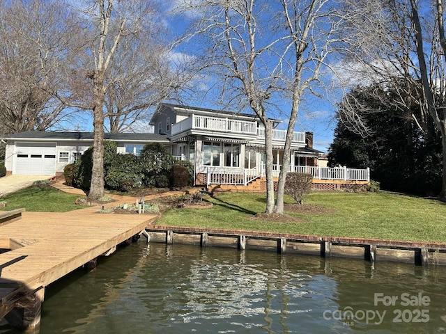 dock area featuring a balcony, a lawn, and a water view