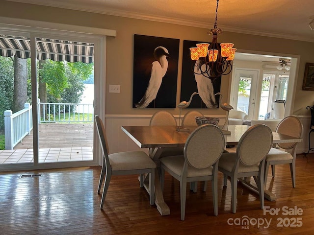 dining space featuring crown molding, a chandelier, and hardwood / wood-style flooring