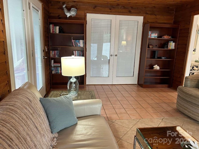 tiled living room with french doors and wooden walls