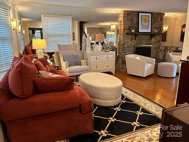 living room with crown molding, a fireplace, and wood-type flooring