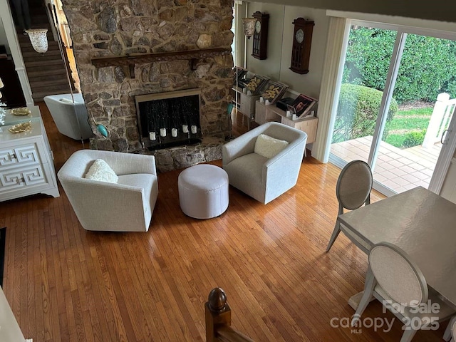 living room featuring a stone fireplace and hardwood / wood-style flooring