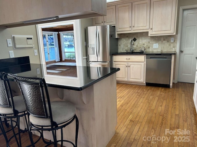 kitchen featuring a breakfast bar area, stainless steel appliances, tasteful backsplash, and sink