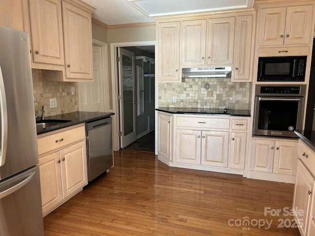 kitchen with hardwood / wood-style floors, decorative backsplash, a textured ceiling, black appliances, and sink