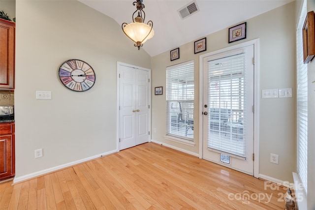 interior space featuring lofted ceiling and light hardwood / wood-style floors