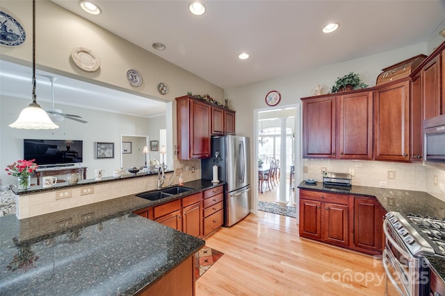 kitchen with decorative backsplash, sink, hanging light fixtures, appliances with stainless steel finishes, and dark stone counters