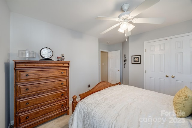 carpeted bedroom featuring ceiling fan and a closet