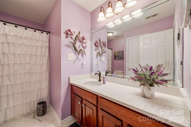 bathroom with toilet, vanity, and walk in shower