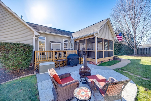 view of patio with grilling area, a deck, a sunroom, and an outdoor fire pit