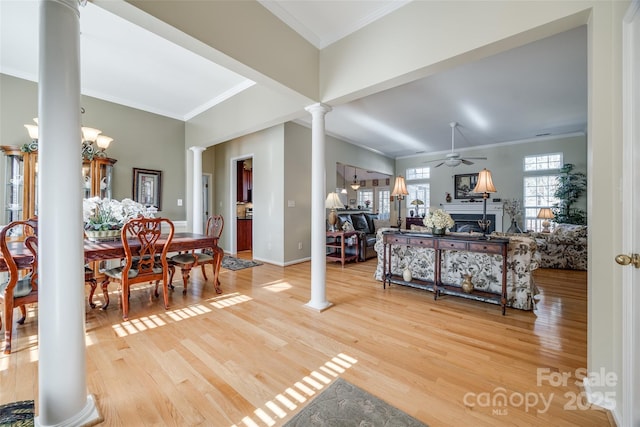 dining room with decorative columns, hardwood / wood-style floors, ornamental molding, and ceiling fan