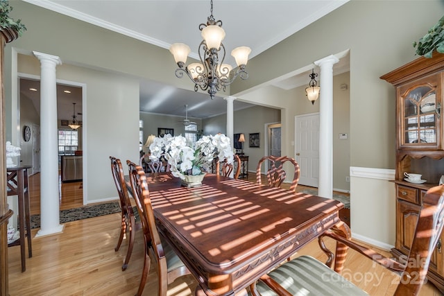 dining room featuring a notable chandelier, ornamental molding, light hardwood / wood-style flooring, and decorative columns