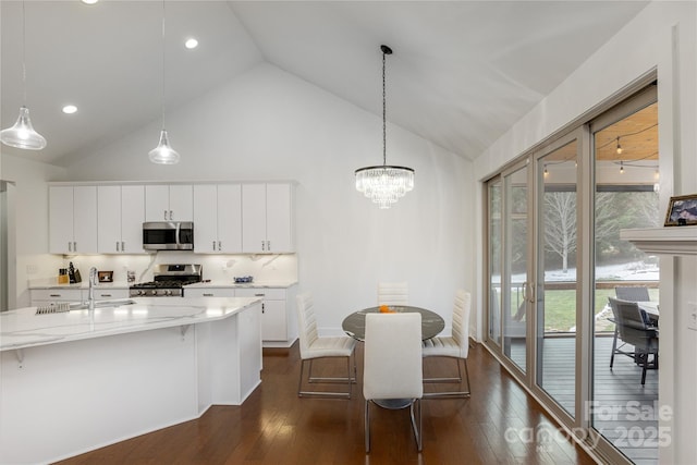 kitchen with white cabinetry, hanging light fixtures, and appliances with stainless steel finishes