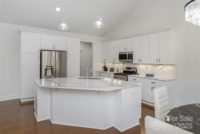 kitchen featuring stainless steel appliances, white cabinetry, sink, and a center island with sink