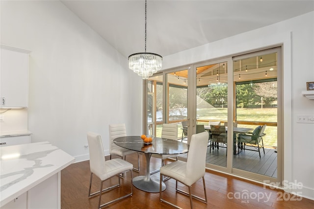 dining room with dark hardwood / wood-style flooring and an inviting chandelier