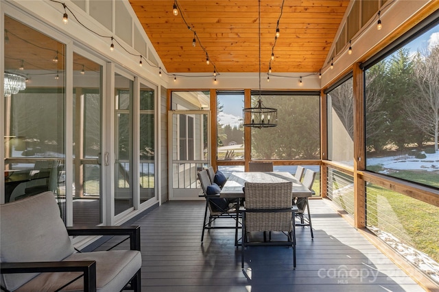 sunroom / solarium with a notable chandelier, lofted ceiling, a wealth of natural light, and wooden ceiling