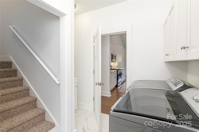 washroom with separate washer and dryer and cabinets