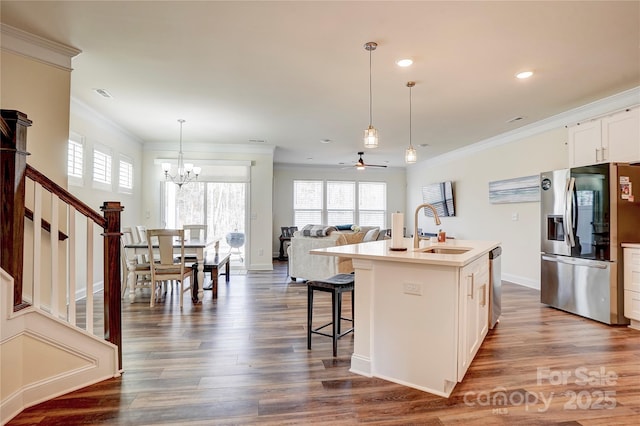 kitchen with appliances with stainless steel finishes, dark hardwood / wood-style floors, a kitchen island with sink, white cabinets, and sink