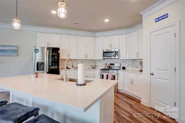 kitchen with decorative light fixtures, white cabinetry, and stainless steel appliances