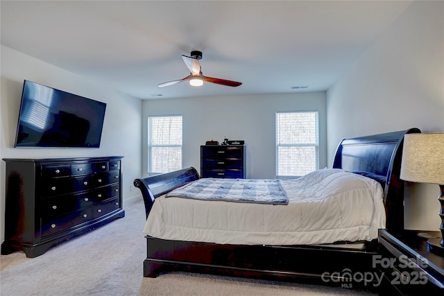 carpeted bedroom with ceiling fan and multiple windows