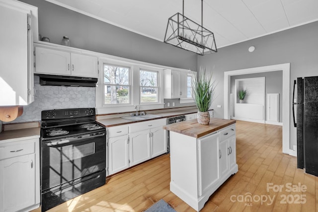 kitchen with sink, butcher block countertops, white cabinetry, pendant lighting, and black appliances