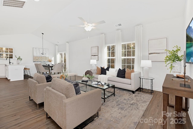 living room featuring hardwood / wood-style flooring, ceiling fan, lofted ceiling, and sink