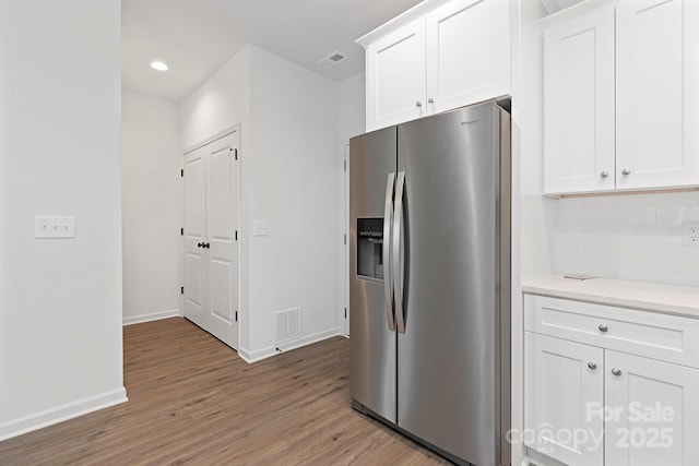 kitchen with white cabinetry, hardwood / wood-style floors, and stainless steel fridge with ice dispenser