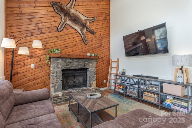 living room with a fireplace, wood walls, and hardwood / wood-style floors