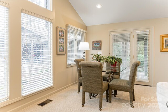 dining space featuring baseboards, visible vents, carpet, and lofted ceiling