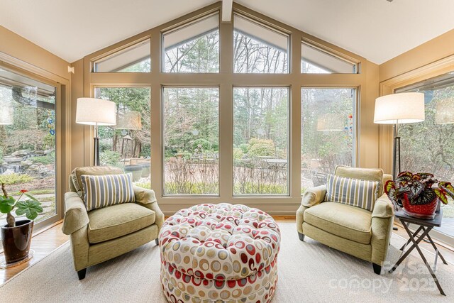sunroom / solarium featuring wood finished floors and lofted ceiling