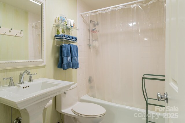 full bath featuring a sink, shower / bathtub combination with curtain, and toilet