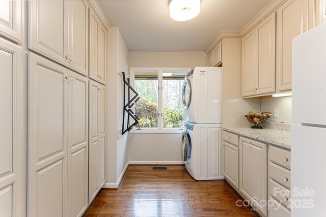 14 Stuyvesant Cres, Asheville, NC 28803 - laundry room featuring estacked washer and dryer, baseboards, wood finished floors, and cabinet space