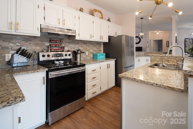 kitchen with appliances with stainless steel finishes, sink, white cabinets, decorative backsplash, and a textured ceiling