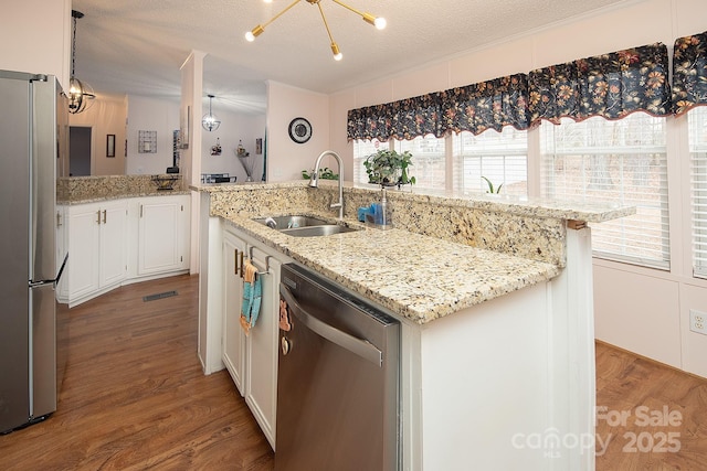 kitchen featuring white cabinetry, sink, a kitchen island with sink, stainless steel appliances, and a textured ceiling