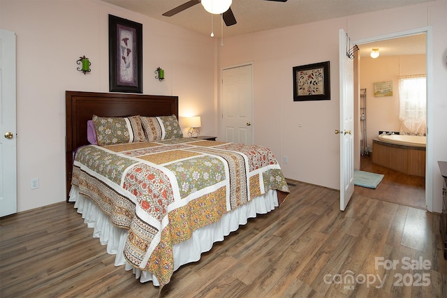 bedroom with connected bathroom, dark hardwood / wood-style floors, and ceiling fan