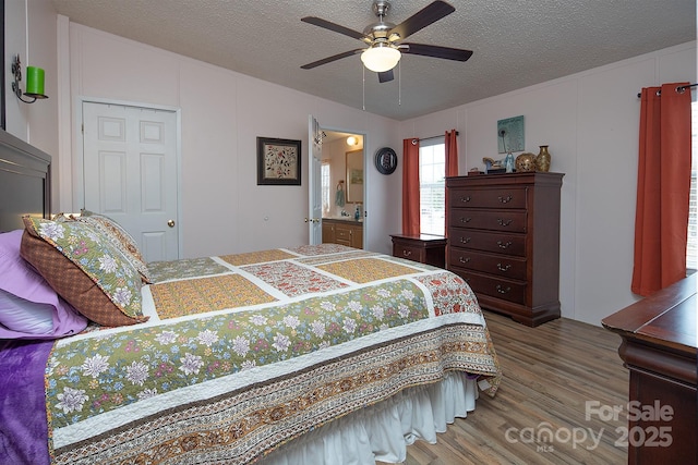 bedroom featuring ensuite bathroom, a textured ceiling, a closet, hardwood / wood-style flooring, and ceiling fan